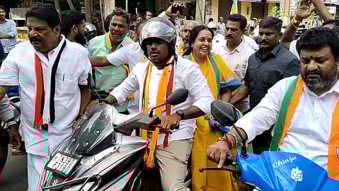 BJP leader K Annamalai engagged in campaigning for Coimbatore north constituency BJP candidate Vanathi Srinivasan by taking her in motor - cycle at Vadavalli in Coimbatore on Tuesday. /Express.
