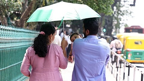 As Kerala reels under an intense spell of summer heat, parents shield their young child from the sun.