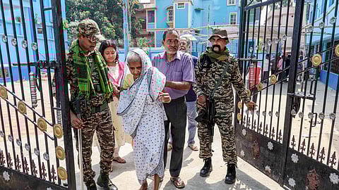 Birbhum: Security personnel assist an elderly woman during voting in the first phase of the West Bengal Assembly elections at a polling station in Bolpur, Birbhum, Thursday, April 23, 2026.
