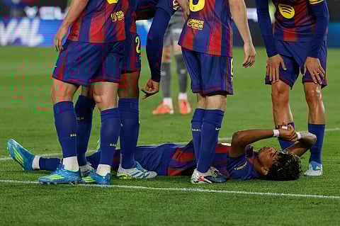 Barcelona's Lamine Yamal lies on the pitch in pain during the Spanish La Liga soccer match between Barcelona and Celta Vigo in Barcelona, Spain, Wednesday, April 22, 2026. 
