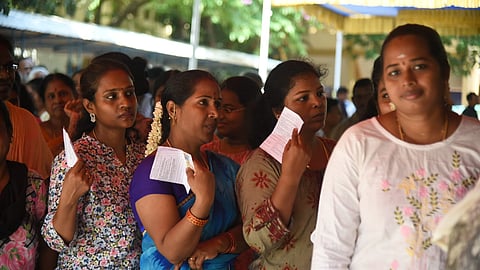 Voters wait to cast their vote at a polling booth during the Tamil Nadu Assembly elections. 