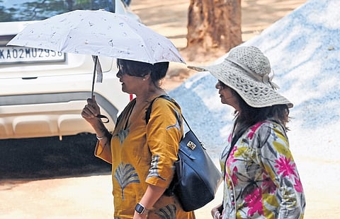 Two women brave the heat and step out in Bengaluru on Friday 