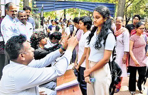 Higher Education Minister MC Sudhakar scans students who arrived for CET at a college in Bengaluru on Friday 