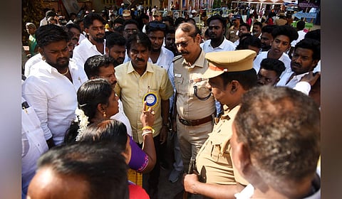 DMK supporters in a heated argument with the police following allegations of TVK agents campaigning outside a polling booth in Kolathur.