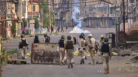 Security personnel fire teargas shells during a clash after thousands demanding permanent peace were stopped from marching towards the Chief Ministe's residence, in Imphal.