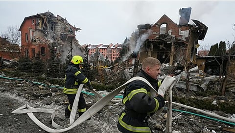 Firefighters put out a fire after a drone hit a residential building during a Russian air attack in Kyiv, Ukraine, Sunday, Feb. 22, 2026.