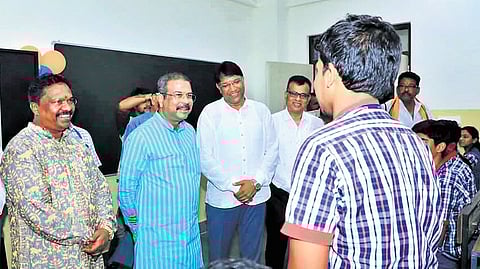 Dharmendra Pradhan interacts with a student of KV-Deogarh in the presence of Panchayati Raj and Drinking Water Minister Rabi Narayan Naik.
