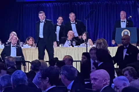 U.S. Secret Service agents surround President Donald Trump before he was taken from the stage after a shooting incident outside the ballroom during the White House Correspondents Dinner on Saturday