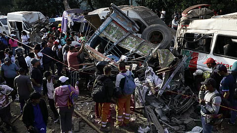 People gather around vehicles damaged in an attack on the Pan-American Highway in Cajibio, Colombia, Saturday, April 25, 2026.