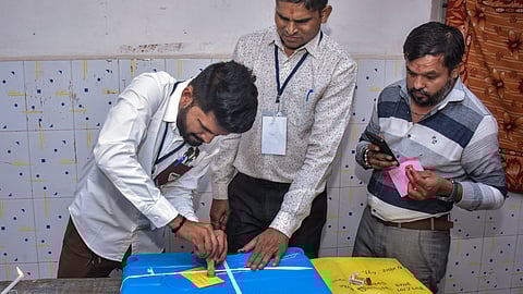 Polling officials seal an EVM after voting for the Gujarat local body polls, in Surat, Sunday, April 26, 2026.