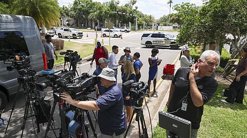 Members of the media document detectives and deputies with the Hillsborough County Sheriff's Office as they investigate inside the Lake Forest subdivision of Tampa, Fla., on Friday, April 24, 2026, where authorities said a man was taken into custody after barricading himself inside a home, in connection to the search for two missing University of South Florida graduate students.