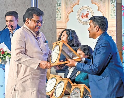 Large and Medium Industries Minister MB Patil felicitates a KSDL staffer during an event in Bengaluru on Tuesday.