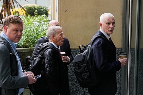 William Frentzen, attorney for Sam Altman, right, and Marc Toberoff, attorney for Elon Musk, center, wait to enter U.S. District Court in Oakland, Calif., Monday, April 27, 2026.