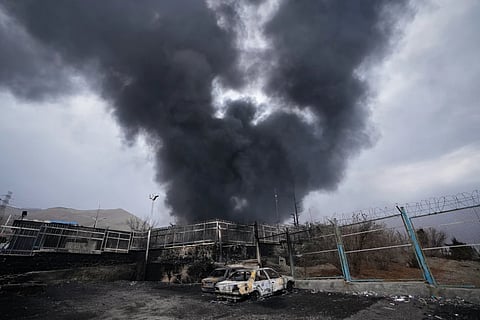 A thick plume of smoke rises from an oil storage facility hit by a U.S.-Israeli strike in Tehran, Iran, March 8, 2026.