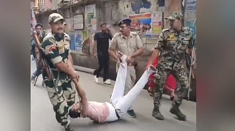 CRPF personnel detain people after a clash erupts in Howrah during the second phase of assembly elections in West Bengal on Wednesday.