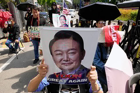 A supporter of former South Korean President Yoon Suk Yeol holds up his portrait during a rally outside of the Seoul High Court in Seoul, South Korea, Wednesday, April 29, 2026. 