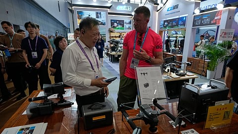 A vendor attends a visitor at a booth showcasing drones at the Canton Fair, in Guangzhou, in southern China’s Guangdong province, Wednesday, April 15, 2026.