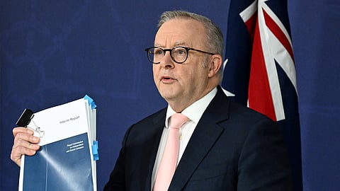 Australian Prime Minister Anthony Albanese holds up the report on antisemitism and social cohesion during a press conference at the Commonwealth Parliamentary Offices in Sydney, Thursday, April 30, 2026.