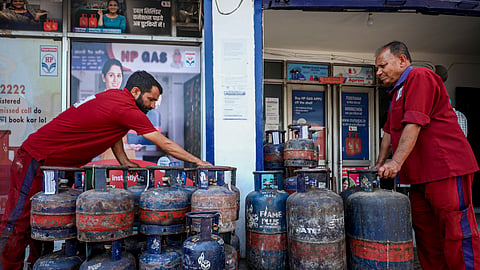 Workers stack LPG cylinders at a gas agency in Jammu, Jammu and Kashmir, on Friday, May 1, 2026.