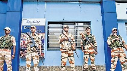 Security personnel outside a strongroom in Kolkata; (R) A screengrab of suspended OC Goutam Das’ controversial post.