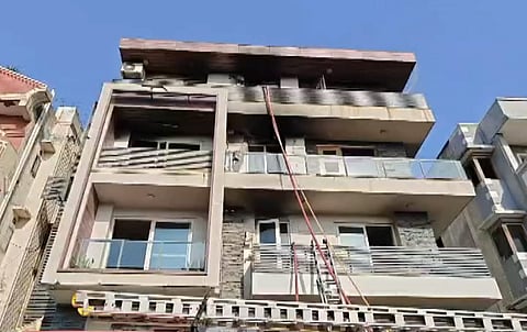 Firemen douse a fire in a four-storey residential building at Vivek Vihar area, in New Delhi, Sunday, May 3, 2026.